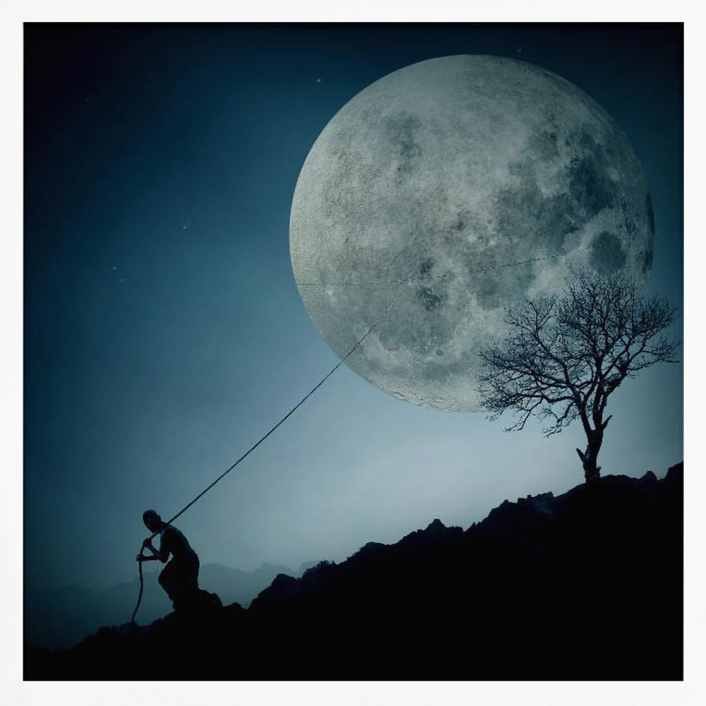 A surreal, framed artwork depicting a silhouette of a person on a dark, rocky hill at night, pulling a rope attached to a massive, detailed full moon, seemingly trying to pull it from the dark blue, star-dusted sky. A bare, silhouetted tree stands on the same hill. Artwork