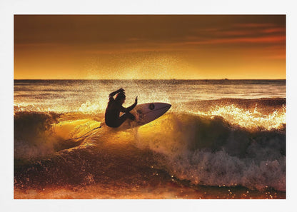 A silhouetted surfer carves a turn on a sun-kissed wave during a vibrant orange sunset, with golden light reflecting off the water and sea spray. Wall Art
