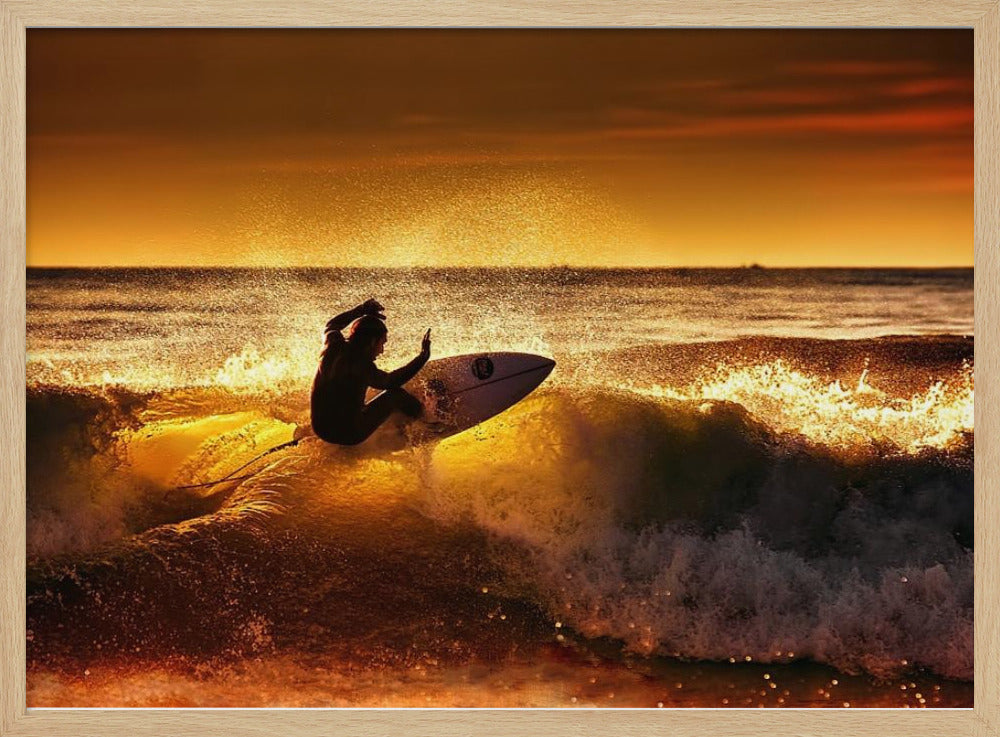 A silhouetted surfer carves a turn on a sun-kissed wave during a vibrant orange sunset, with golden light reflecting off the water and sea spray. Wall Art
