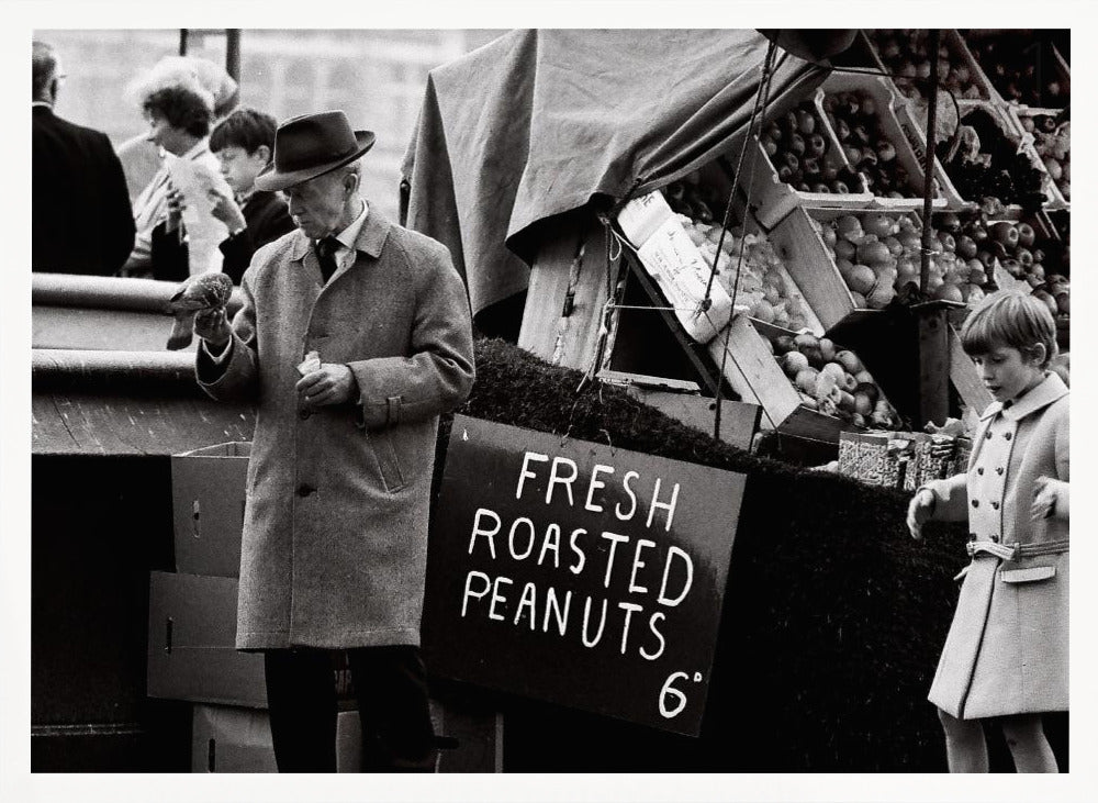 A vintage black and white photograph of an elderly man in a fedora and overcoat feeding a pigeon from his hand at an outdoor market. A sign for 'FRESH ROASTED PEANUTS' is visible next to him, and a young boy in a coat watches nearby. Wall Art