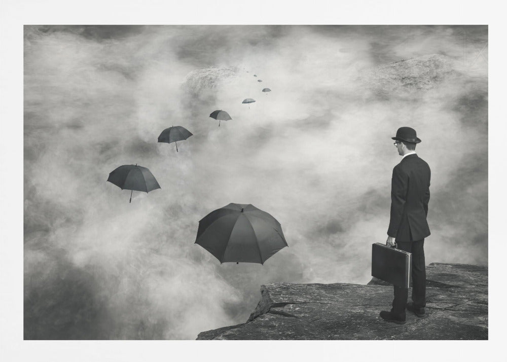 A surreal black and white photograph of a man in a suit and bowler hat holding a briefcase, standing on a cliff edge. He gazes into a foggy expanse where a path of floating black umbrellas leads into the misty distance. Decor