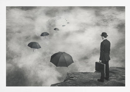 A surreal black and white photograph of a man in a suit and bowler hat holding a briefcase, standing on a cliff edge. He gazes into a foggy expanse where a path of floating black umbrellas leads into the misty distance. Decor