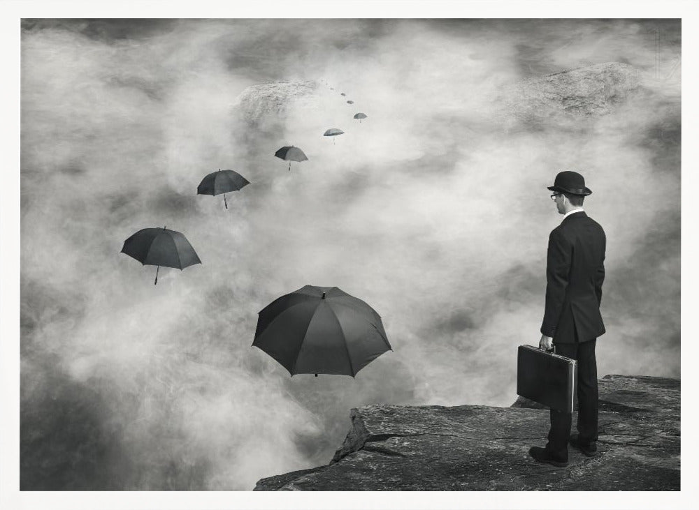 A surreal black and white photograph of a man in a suit and bowler hat holding a briefcase, standing on a cliff edge. He gazes into a foggy expanse where a path of floating black umbrellas leads into the misty distance. Decor