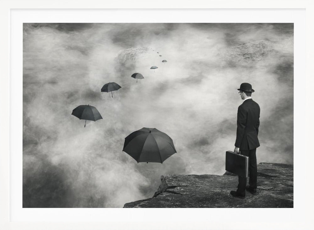 A surreal black and white photograph of a man in a suit and bowler hat holding a briefcase, standing on a cliff edge. He gazes into a foggy expanse where a path of floating black umbrellas leads into the misty distance. Decor