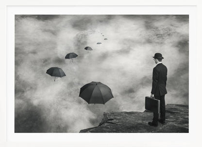 A surreal black and white photograph of a man in a suit and bowler hat holding a briefcase, standing on a cliff edge. He gazes into a foggy expanse where a path of floating black umbrellas leads into the misty distance. Decor