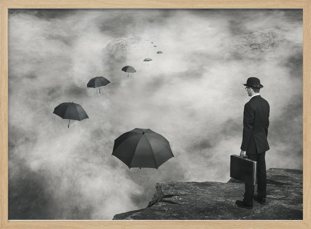 A surreal black and white photograph of a man in a suit and bowler hat holding a briefcase, standing on a cliff edge. He gazes into a foggy expanse where a path of floating black umbrellas leads into the misty distance. Decor
