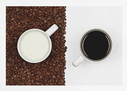 A top-down, split-screen photograph showing a contrast between coffee and milk. On the left, a white mug of milk sits on a bed of roasted coffee beans. On the right, a white mug of black coffee rests on a clean white background, creating a stark visual divide. Artwork