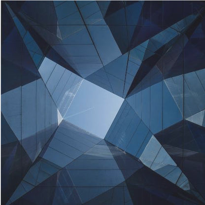 A framed, low-angle photograph looking up towards the sky, surrounded by the reflective blue glass facades of modern buildings which create a kaleidoscopic, geometric pattern. Print