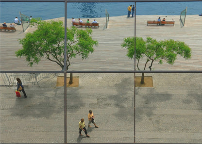 A framed, multi-pane window view showing a composite urban scene. The top panes reflect a sunny day on a wooden boardwalk by blue water, with people relaxing and green trees. The bottom panes show a direct view of a paved street below, with a few pedestrians walking. The window mullions create a grid that divides the distinct scenes. Wall Art