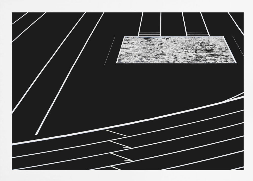 A high-contrast, black and white abstract artwork depicting a running track from an elevated perspective. Stark white lines representing lanes curve across a solid black background. In the upper portion, a rectangular shape filled with a textured, water-like pattern replaces a typical sand pit. The entire piece is presented within a silver frame. Print