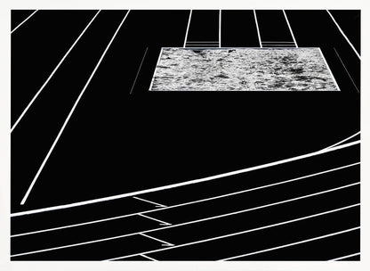 A high-contrast, black and white abstract artwork depicting a running track from an elevated perspective. Stark white lines representing lanes curve across a solid black background. In the upper portion, a rectangular shape filled with a textured, water-like pattern replaces a typical sand pit. The entire piece is presented within a silver frame. Print
