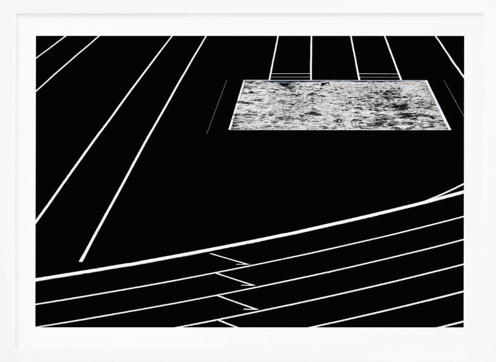 A high-contrast, black and white abstract artwork depicting a running track from an elevated perspective. Stark white lines representing lanes curve across a solid black background. In the upper portion, a rectangular shape filled with a textured, water-like pattern replaces a typical sand pit. The entire piece is presented within a silver frame. Print