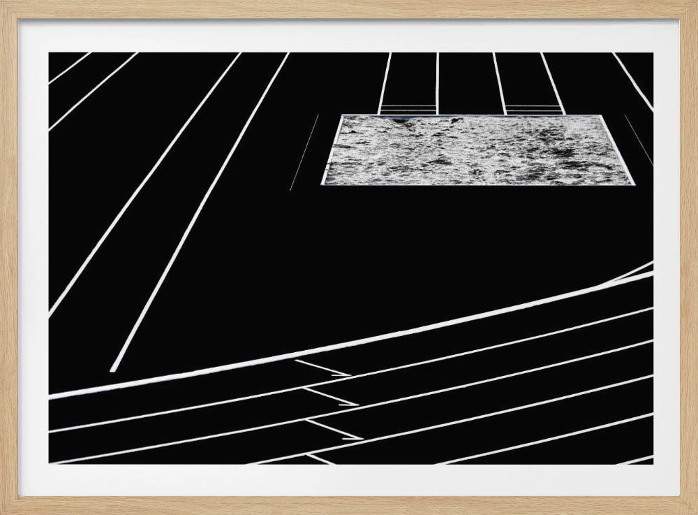 A high-contrast, black and white abstract artwork depicting a running track from an elevated perspective. Stark white lines representing lanes curve across a solid black background. In the upper portion, a rectangular shape filled with a textured, water-like pattern replaces a typical sand pit. The entire piece is presented within a silver frame. Print