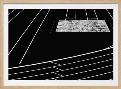 A high-contrast, black and white abstract artwork depicting a running track from an elevated perspective. Stark white lines representing lanes curve across a solid black background. In the upper portion, a rectangular shape filled with a textured, water-like pattern replaces a typical sand pit. The entire piece is presented within a silver frame. Print