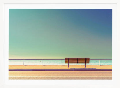 A minimalist, retro-toned photograph of a solitary wooden bench on a sunlit seaside promenade, overlooking a calm turquoise ocean under a vast, clear blue-green sky. Poster