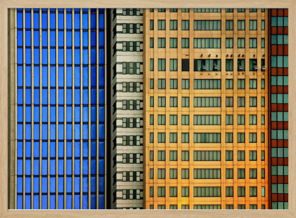 An abstract architectural photograph showing the colorful gridded facades of three adjacent skyscrapers, featuring a blue-windowed building, a white building, and a yellow building, all contained within a silver frame. Wall Art