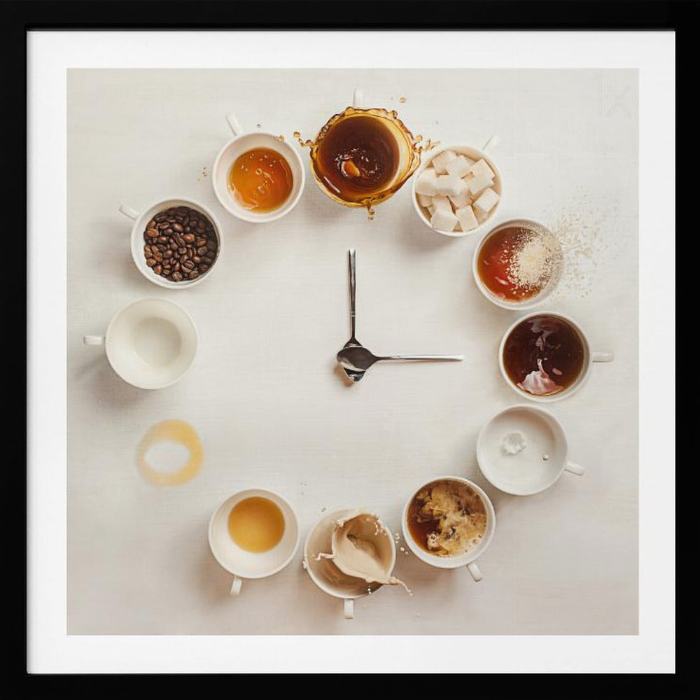 A creative flat lay photograph of a clock made from coffee cups and ingredients. Twelve white cups are arranged in a circle on a white background, each representing an hour and filled with different coffee-related items like beans, honey, sugar cubes, and various stages of coffee with milk splashing. In the center, two silver spoons form the hands of the clock. The entire image is presented within a light wood frame. Decor