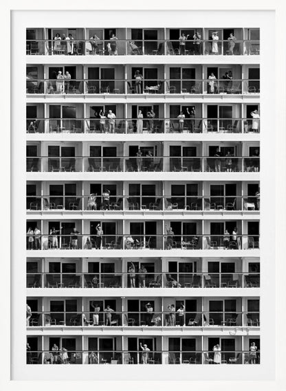 A black and white, high-contrast photograph of the side of a cruise ship, showing a grid of balconies across multiple decks. Various passengers are visible on their balconies, some waving, some relaxing, and some observing, creating a pattern of individual human stories within the repetitive architectural structure. Poster
