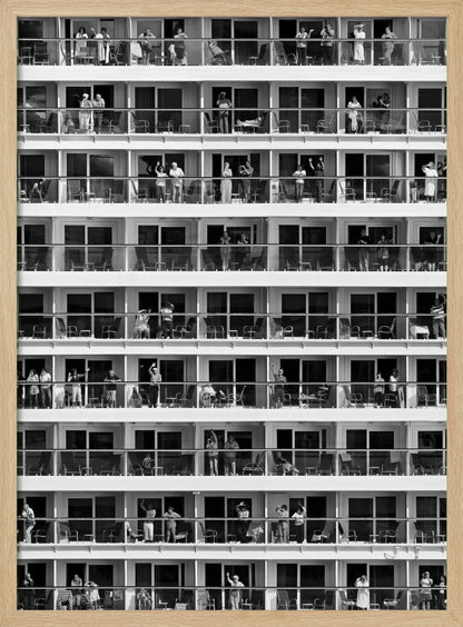 A black and white, high-contrast photograph of the side of a cruise ship, showing a grid of balconies across multiple decks. Various passengers are visible on their balconies, some waving, some relaxing, and some observing, creating a pattern of individual human stories within the repetitive architectural structure. Poster