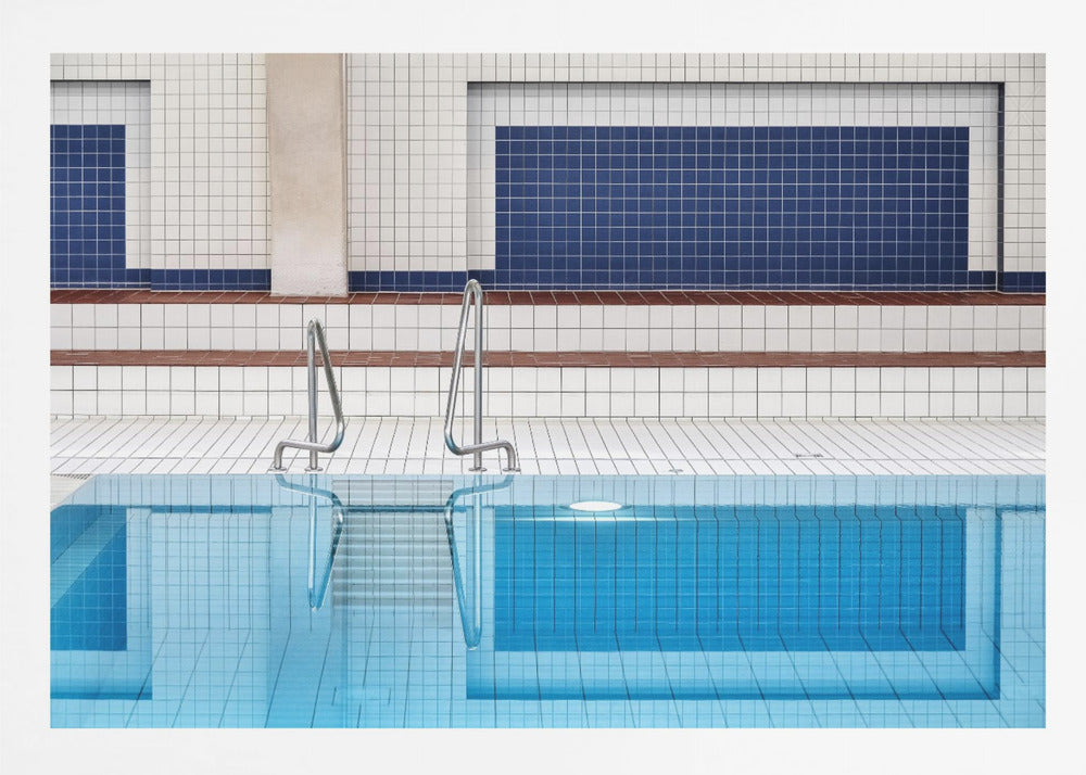 A framed, symmetrical photograph of a minimalist indoor swimming pool with blue and white tiles, stainless steel ladders, and a calm, reflective water surface. Poster