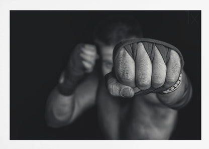 A dramatic black and white close-up photograph of a boxer's wrapped fist punching towards the camera. The fighter's body and other fist are blurred in the background, creating a powerful and intense mood. Print