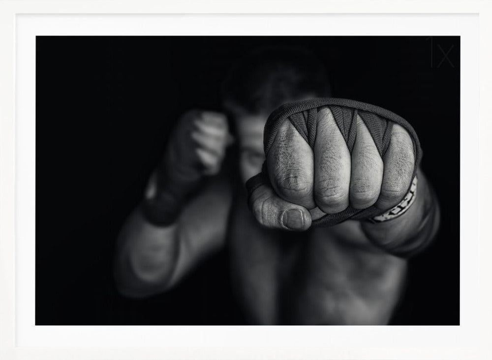 A dramatic black and white close-up photograph of a boxer's wrapped fist punching towards the camera. The fighter's body and other fist are blurred in the background, creating a powerful and intense mood. Print