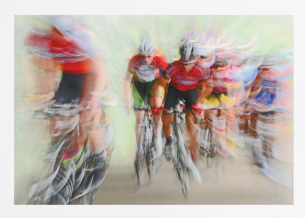 An abstract photograph of a group of cyclists in a race, captured with motion blur to create a dynamic sense of speed. The riders' red jerseys and the green background are streaked together, with a silver frame surrounding the image. Artwork