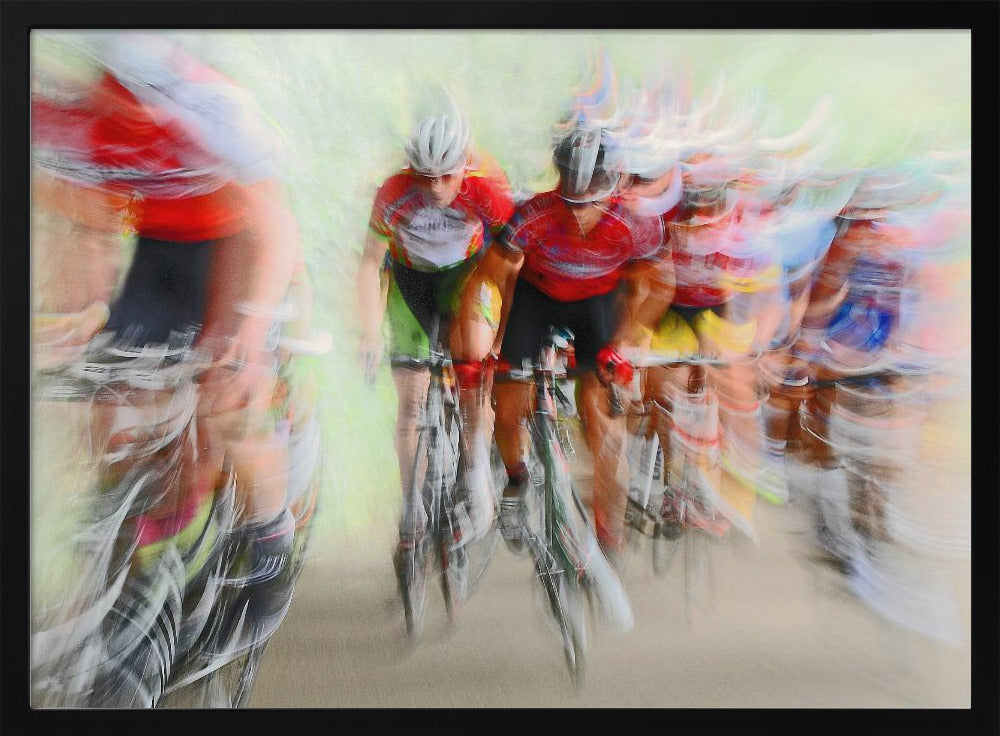 An abstract photograph of a group of cyclists in a race, captured with motion blur to create a dynamic sense of speed. The riders' red jerseys and the green background are streaked together, with a silver frame surrounding the image. Artwork