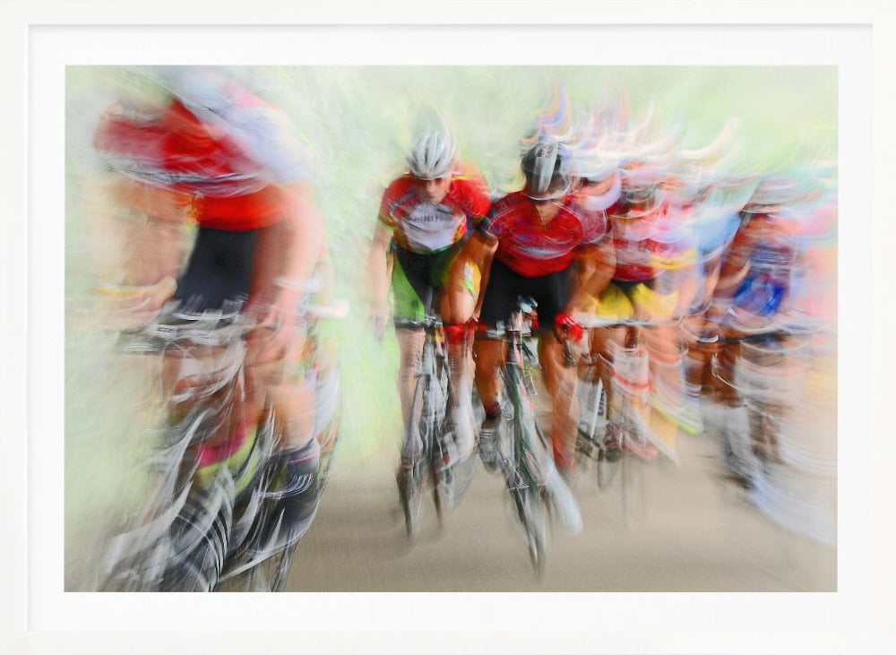 An abstract photograph of a group of cyclists in a race, captured with motion blur to create a dynamic sense of speed. The riders' red jerseys and the green background are streaked together, with a silver frame surrounding the image. Artwork