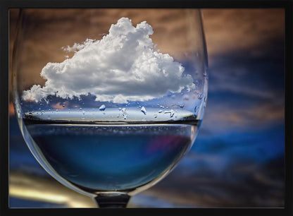 A surreal close-up of a wine glass holding blue liquid and a single white cloud, with water droplets on the glass, set against a blurred background and enclosed in a silver frame. Print