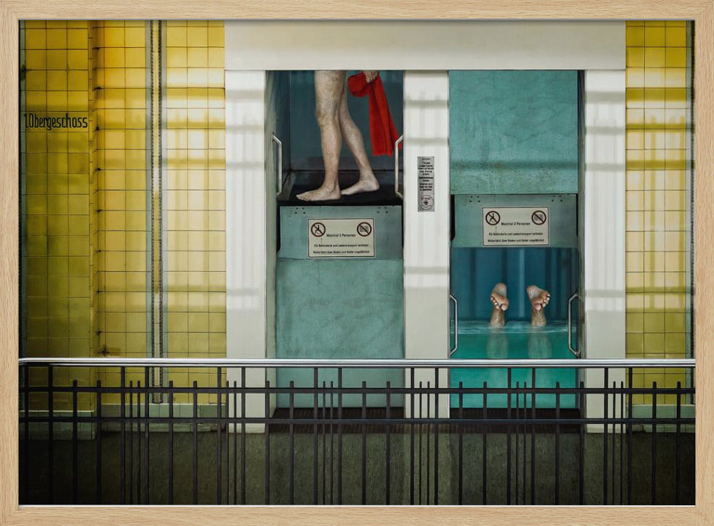 A surreal, framed artwork depicting two teal-colored vertical cabins against a yellow tiled wall. In the left cabin, a person's bare legs are visible as they hold a red towel. In the right cabin, which is filled with water, only a pair of feet can be seen submerged. A black railing is in the foreground, adding to the strange, layered composition. Artwork