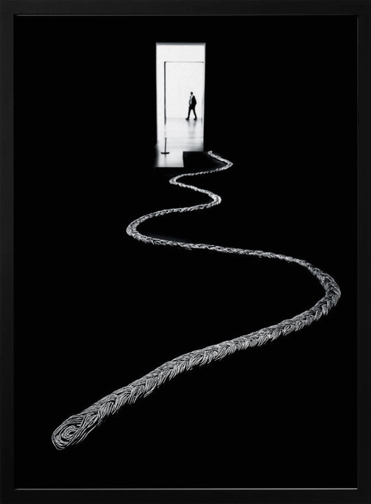 A high-contrast, black and white photograph of a thick, silver, braided rope winding across a black floor, leading towards a brightly lit doorway in the distance where a silhouetted man is walking away. Wall Art