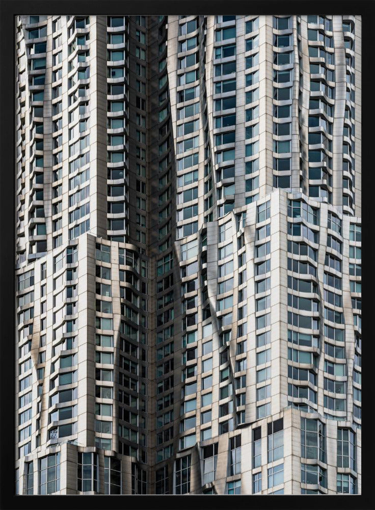 A close-up photograph of the facade of a modern skyscraper with an undulating, wave-like metallic exterior. The building is filled with windows that reflect the light, creating a dynamic pattern of highlights and shadows, all captured within a black frame. Print