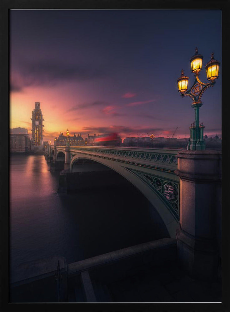 A breathtaking twilight view of Westminster Bridge in London, with the iconic Big Ben illuminated in the background against a purple and orange sunset sky. A vintage street lamp glows warmly in the foreground, and the motion blur of a red bus crosses the bridge over the calm River Thames. Print