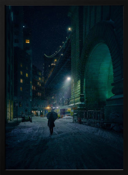 A lone person holding an umbrella walks down a snow-covered street at night, dwarfed by the massive, green-lit stone archway of the Brooklyn Bridge as snow falls around them. Print