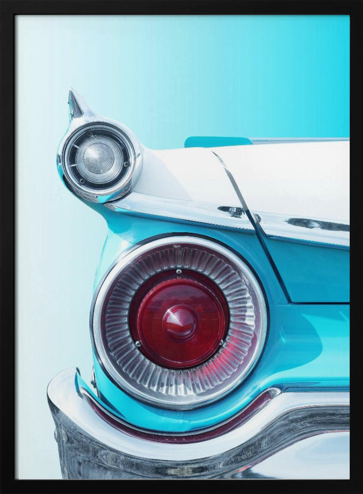 A close-up, framed photograph of the tail fin of a vintage turquoise and white car. The focus is on the large, round, red taillight and the smaller chrome-encased light on the fin, set against a solid light blue background. Poster