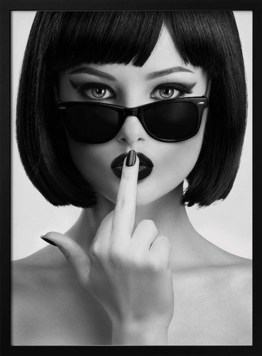 A striking black and white portrait of a woman with a sharp bob haircut, sunglasses, and bold makeup. She holds one finger with a black-painted nail up to her dark lips, making a 'shushing' gesture. Poster