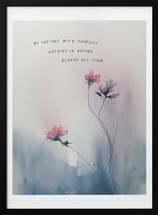 A watercolor painting of delicate pink flowers on thin stems against a soft blue and white background. Above the flowers is the inspirational quote 'Be patient with yourself, nothing in nature blooms all year' in a simple, handwritten font. The artwork is shown in a black frame. Print