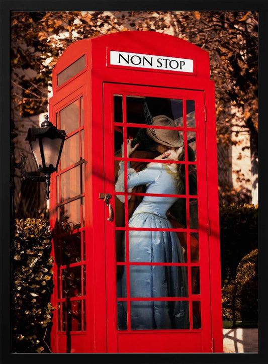 A couple in vintage clothing share a passionate kiss inside a classic bright red telephone booth. The woman is wearing a light blue dress, and the man wears a hat. The sign above the booth door reads 'NON STOP'. The setting appears to be outdoors in autumn. Wall Art