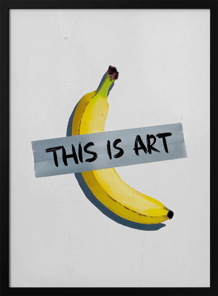 A framed artwork depicting a single yellow banana taped to a white wall with a grey strip of tape that reads 'THIS IS ART' in black marker-style font. Artwork