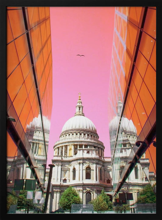 A low-angle, surrealist photograph of a classic white dome cathedral, framed perfectly between two modern orange glass buildings. The cathedral's reflection is visible on the buildings' surfaces against a vibrant, solid pink sky with a lone bird in flight. Poster
