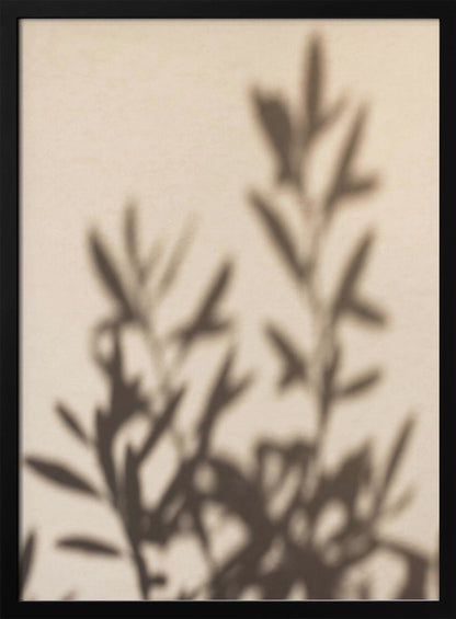 A framed photograph featuring the soft, out-of-focus shadow of a leafy plant projected onto a warm, beige-colored wall. The image has a minimalist and tranquil aesthetic, focusing on the interplay of light and shadow. Wall Art
