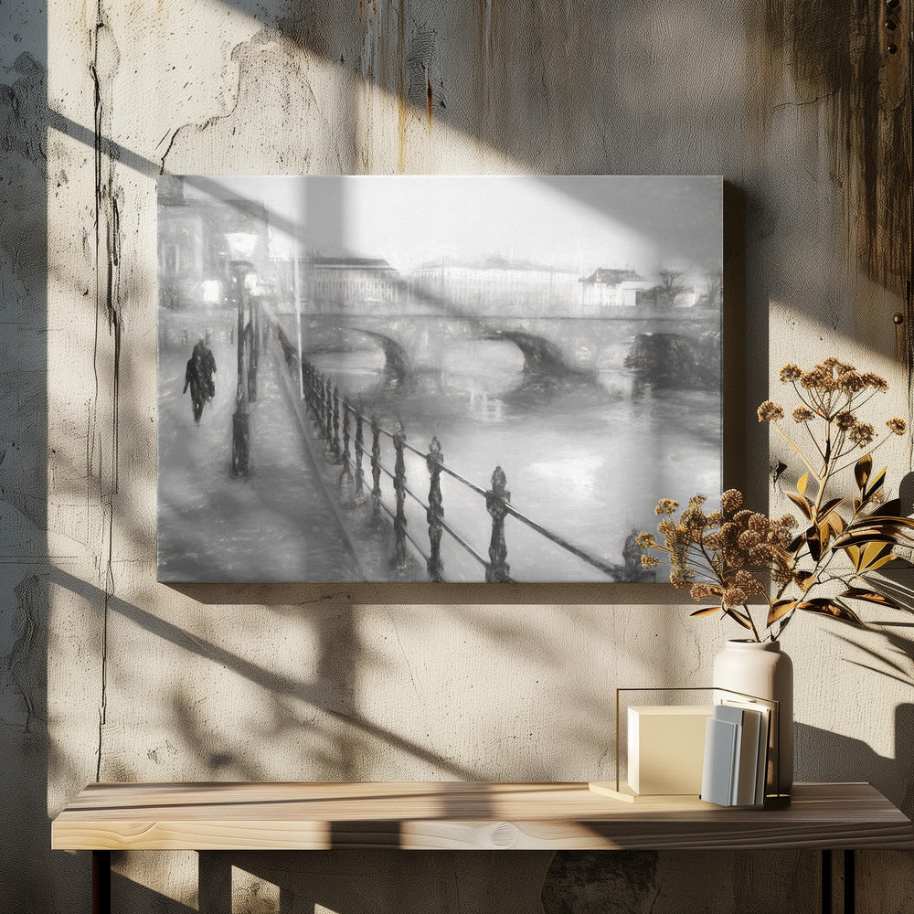 A framed, black and white impressionistic artwork of a city scene on a foggy or rainy day. In the foreground, a dark metal railing runs along a riverside walkway where a person in a dark coat is walking. An arched stone bridge crosses the river in the midground, with hazy buildings visible in the background, creating a moody and atmospheric scene. Wall Art
