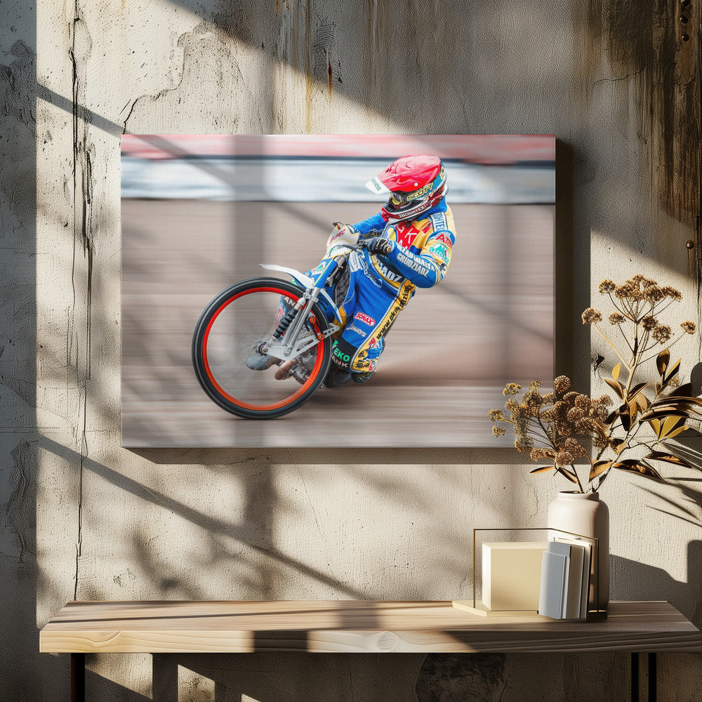 A speedway motorcycle racer in a blue and yellow suit with a red helmet leans sharply into a turn on a dirt track, with motion blur in the background conveying a sense of high speed. Print