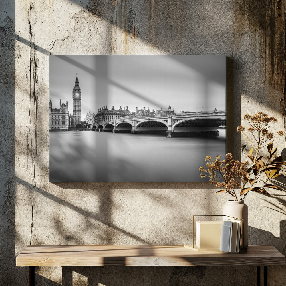 A black and white long-exposure photograph of the Elizabeth Tower (Big Ben) and the Houses of Parliament in London, viewed from across the River Thames. Westminster Bridge stretches across the frame over the smooth, milky water. The image is presented in a silver frame. Artwork