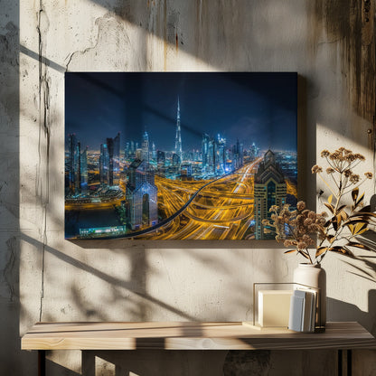 A vibrant aerial photograph of the Dubai skyline at night, with the iconic Burj Khalifa towering in the center. A complex web of brightly lit highways with light trails from traffic dominates the foreground, weaving between modern skyscrapers under a starry night sky. Decor