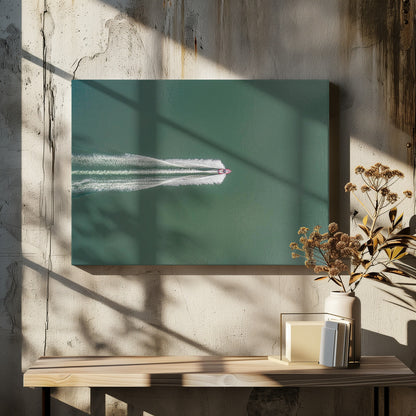 An aerial top-down photograph of a red motorboat speeding across a vast expanse of calm, green water, leaving a long, white, frothy wake behind it. The scene is presented within a simple silver frame. Print