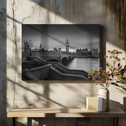 A framed, black and white, long-exposure photograph of the London skyline featuring the Houses of Parliament and the Big Ben clock tower across the River Thames. In the foreground, stone steps lead down towards Westminster Bridge, and the water of the river is smooth and reflective under a dark, cloudy sky. Print