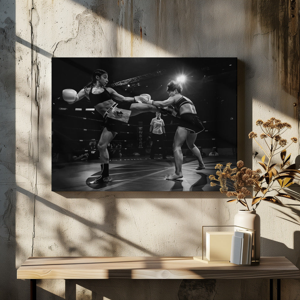 A dramatic black and white action photograph of two female kickboxers in a ring. One fighter, airborne, executes a high kick that connects with the other fighter's gloves, who is bracing for the impact. A referee stands in the background under bright arena lights. Poster