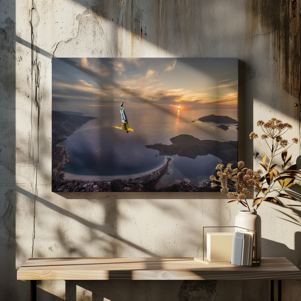 A breathtaking aerial view of a skydiver in a head-down position, freefalling over a vast coastal bay at sunset. The setting sun casts a golden glow over the ocean and clouds, highlighting the islands and coastline below. Decor